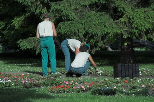 Workers performing safe garden maintenance with visible safety measures